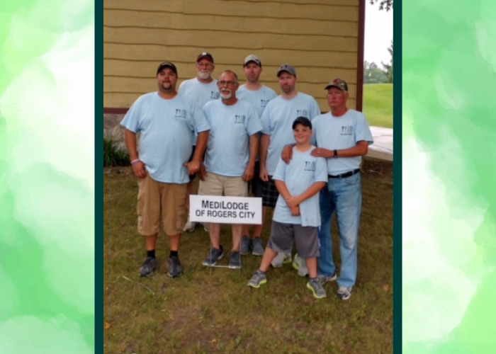 The Luetzow family standing by MediLodge of Rogers City's hole